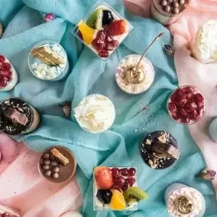A display of mini dessert options on blue and pink swatches of fabric.