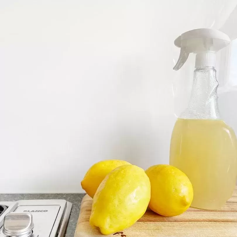 All-natural cleaning fluid in a spray bottle next to lemons